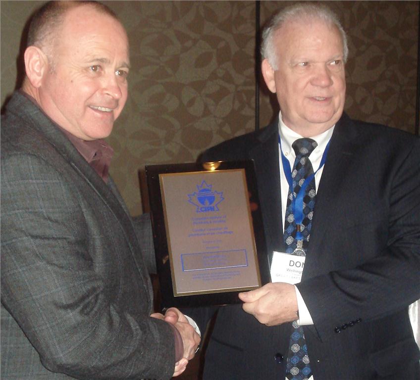 John Hammill, CIPH chairman of the board presents a 50 year service award to Don Wellington (r) of Great Lakes Copper (formerly Wolverine). Wellington started his career in Wolverine's mailroom and is now GLC's president.