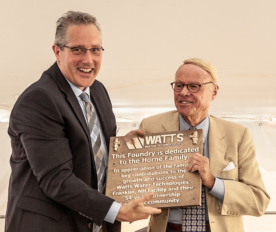 Tyler Stone (l), director of operations presents a commemorative plaque to Timothy Horne, who took over the reins of the company in 1978 until his retirement in 2002. It was under his leadership that the company went public and began the acquisition program that established Watts as an international presence. Photo ImagesPlus Photography