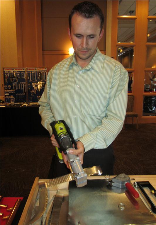 Ryan Carr, sales representative and marketing coordinator for E.S. Gallagher Sales Ltd., demonstrates how the Malco C5A attaches to a cordless drill to turn it into a power-assisted crimper.
