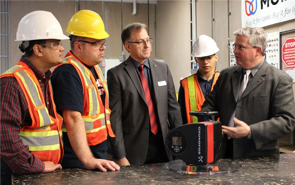Grundfos Canada president Simon Feddema (r) explains the workings of the company's high-efficient MAGNA3 circular pump to KPU plumbing students Ravinder Walia, Richard Baziuk and Aws Elmakayed while plumbing instructor Sven Rohde observes.