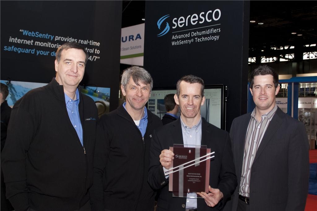 (l to r) Mark Palitza, regional sales manager, and Ralph Kittler, vice president-sales for Seresco Technologies, present Ed Carney and Glen Kilmer, of Kilmer Environmental, Mississauga, ON with Seresco's Rep of the Year-2014 award at AHR.