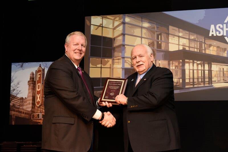 Tom Phoenix (l), 2014/2015 ASHRAE president, presents the DSA to Norm Grusnick of ECCO Supply.