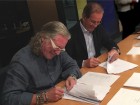 Taco's John Hazen White, Jr. (l) and Elio Marioni of Askoll sign sale documents in Dueville, Italy.